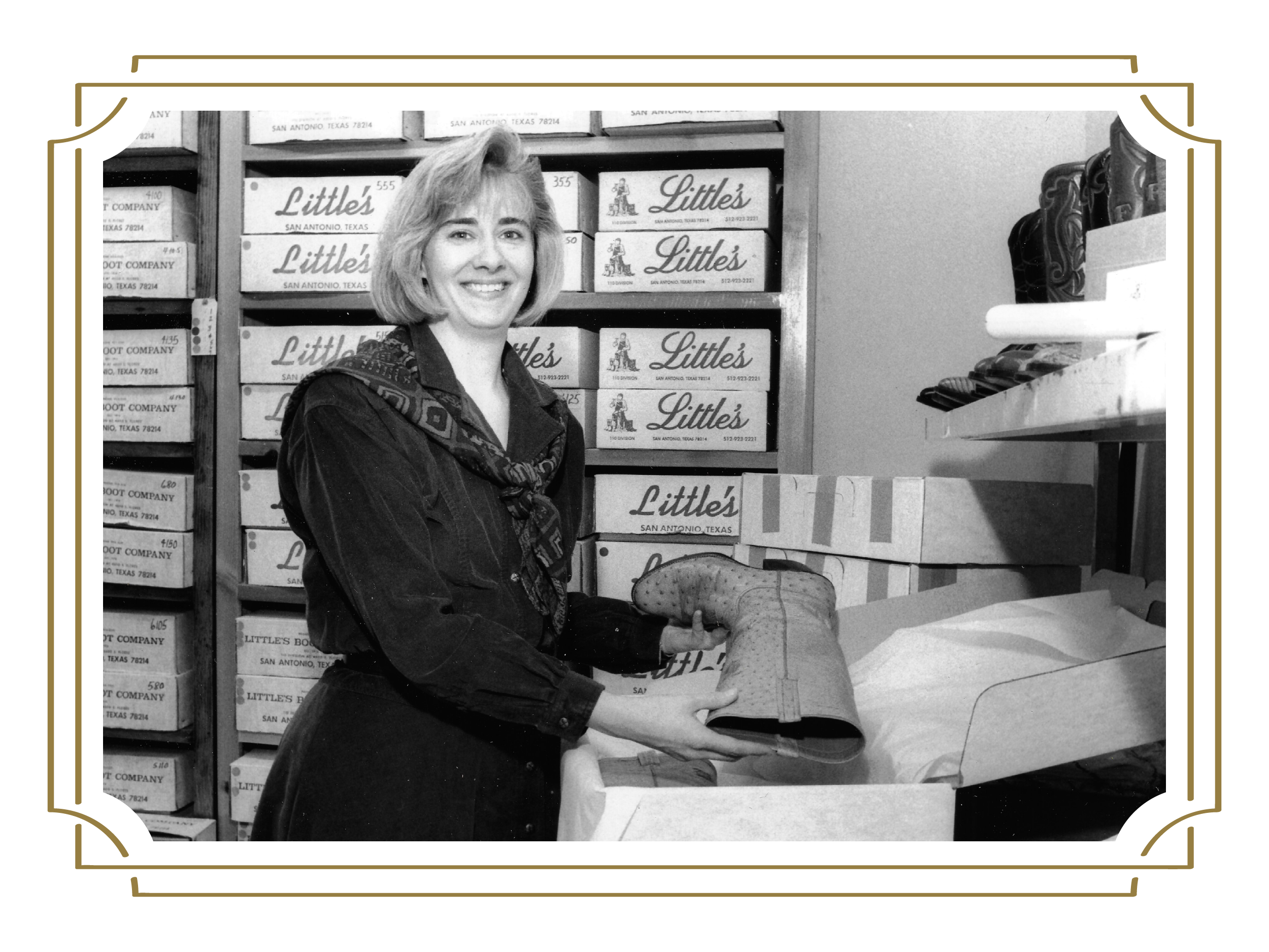 A woman stands in a store, holding a boot among shelves filled with boxes labeled "Little's."